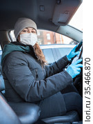 Adult woman driving to work wearing face mask and surgical gloves dring covid-19 epidemic, looking at camera. Стоковое фото, фотограф Кекяляйнен Андрей / Фотобанк Лори