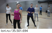 Smiling dancing people practicing bachata movements in dance studio for adults. Стоковое видео, видеограф Яков Филимонов / Фотобанк Лори