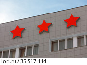 Гостиница три звезды. Вечерняя подсветка красных звезд крупным планом на верху здания отеля (2021 год). Редакционное фото, фотограф Grigory_Gez / Фотобанк Лори