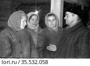 Мужчина беседует с женщинами передовиками производства на выборке слюды, они стоят в небольшом помещении рядом с деревянной опорой, Эмельджак, Якутия, 1961. Редакционное фото, фотограф Варфоломей Тетерин / Фотобанк Лори