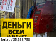 Рекламное объявление "Деньги всем за 15 минут" на телефонном аппарате в городе Москве, Россия (2021 год). Редакционное фото, фотограф Николай Винокуров / Фотобанк Лори