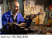 Gunsmith assembling smallbore sporting pistol in workshop. Стоковое фото, фотограф Яков Филимонов / Фотобанк Лори