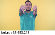 Young sporty man giving thumbs up and than giving thumbs down and shaking hand for no. Стоковое видео, видеограф Mihail Mihaylov / Фотобанк Лори