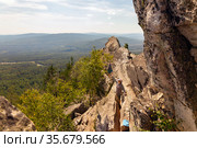 man and woman tourists on the rocky peak Aleksandrovskaya Sopka against the background of the city of Zlatoust on a summer sunny day. Стоковое фото, фотограф Акиньшин Владимир / Фотобанк Лори