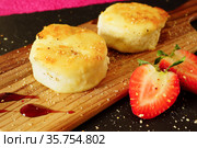 Сырники с клубникой. Два жаренных творожника на черном подносе. Крупный план. Стоковое фото, фотограф ирина реброва / Фотобанк Лори