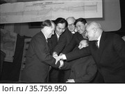 Члены якутского филиала Академии Наук стоят рядом и жмут руку человеку защитившему диссертацию, Бобров Анатолий Кузьмич и его официальный оппонент доктор геологических наук Сенников Валериан Матвеевич, Якутия, 25 января 1964. Редакционное фото, фотограф Варфоломей Тетерин / Фотобанк Лори