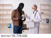 Masked man burglar bribing old doctor for getting vaccine. Стоковое фото, фотограф Elnur / Фотобанк Лори