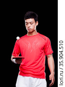 Man playing ping pong, black background. Стоковое фото, агентство Ingram Publishing / Фотобанк Лори