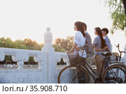 Two couples by HouHai Lake with Bicycles in Beijing. Стоковое фото, агентство Ingram Publishing / Фотобанк Лори