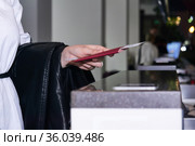 Woman traveler's hand holding out passport and air ticket for passport control at the airport. Стоковое фото, фотограф Евгений Харитонов / Фотобанк Лори