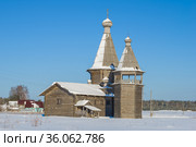 Старинная деревянная церковь Иоанна Златоуста с колокольней в деревне Саунино Каргопольского района солнечным февральским днем. Архангельская область, Россия (2021 год). Стоковое фото, фотограф Виктор Карасев / Фотобанк Лори