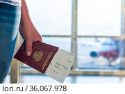 Closeup of female holding passports and boarding pass at airport. Стоковое фото, фотограф Константин Лабунский / Фотобанк Лори