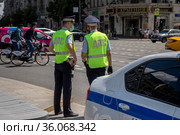 Инспекторы ГИБДД стоят на посту на перекрестке Тверской улице в центре города Москвы и обеспечивает безопасность движения на дороге, Россия (2021 год). Редакционное фото, фотограф Николай Винокуров / Фотобанк Лори