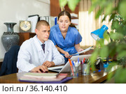 Young colleagues-doctors discuss the appointment of treatment, sitting at the computer in the office. Стоковое фото, фотограф Яков Филимонов / Фотобанк Лори