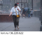 A smiling woman without an umbrella walks in the rain (2021 год). Редакционное фото, фотограф Сайганов Александр / Фотобанк Лори