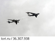 Самолет-заправщик Ил-78 и стратегический бомбардировщик-ракетоносец Ту-95МС "Медведь". Имитация дозаправки в воздухе в небе над Красной площадью Москвы во время воздушного парада Победы (2021 год). Редакционное фото, фотограф Free Wind / Фотобанк Лори