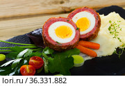 Dish scotch egg with tomatoes, mashed potatoes and greens, traditional Scottish cuisine. Стоковое фото, фотограф Яков Филимонов / Фотобанк Лори