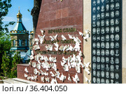 Воинский мемориал с бумажными белыми голубями на фоне Лазаревской церкви. Пятигорск. Ставропольский край (2021 год). Редакционное фото, фотограф Сергей Афанасьев / Фотобанк Лори