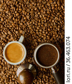Portafilter with сoffee tablet, Temper and espresso cup on the background of crumbled coffee beans. Стоковое фото, фотограф Алексей Голованов / Фотобанк Лори