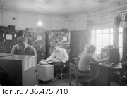 Работники полярные научные станции во время проведения научных исследований, сотрудники метеорологического центра рядом с электронным оборудованием, село Уэлен, Чукотка, 1970 год. Редакционное фото, фотограф Варфоломей Тетерин / Фотобанк Лори