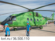 Транспортировка нового российского военного транспортного вертолёта Миль Ми-38Т в цифровом камуфляже на Международном авиасалоне МАКС-2019, Жуковский, Россия, вид сбоку. Редакционное фото, фотограф Малышев Андрей / Фотобанк Лори