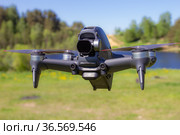Moscow, 31 MAY 2021 : A new DJI FPV drone is flying during a sunny day on grass in beckground. Top Front View. Headless Quadcopter with Digital 4K 60 fps Hasselblad Camera and Remote Control. Стоковое фото, фотограф Алексей Ширманов / Фотобанк Лори