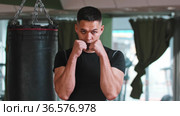 Young man boxer passing by the punching bag and stands in the protective stance. Стоковое видео, видеограф Константин Шишкин / Фотобанк Лори
