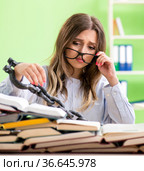 Young female student chained to the desk and preparing for exams. Стоковое фото, фотограф Elnur / Фотобанк Лори