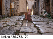 Detail shot of female legs wearing comfortable travel sandals walking on old medieval cobblestones street dring sightseeing city tour. Travel, tourism and adventure concept. Стоковое фото, фотограф Matej Kastelic / Фотобанк Лори