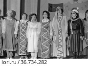 Женщины на сцене театра, они одеты в традиционную одежду разных культур и народов советского Союза, представительницы разных национальностей выступают, флаг и карта СССР на заднем плане, Якутия. Редакционное фото, фотограф Варфоломей Тетерин / Фотобанк Лори