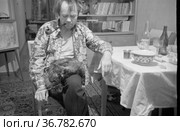 Портрет мужчины с длиной курительной трубкой, он сидит в домашней обстановке с котом на коленях, и курит табак, праздничное застолье с гостями , Токарев и Морозов в гостях у Тетериных. Редакционное фото, фотограф Варфоломей Тетерин / Фотобанк Лори