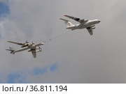 Самолет-заправщик Ил-78 и стратегический бомбардировщик-ракетоносец Ту-95МС "Медведь". Имитация дозаправки в воздухе в небе над Красной площадью Москвы во время генеральной репетиции воздушного парада Победы (2021 год). Редакционное фото, фотограф Free Wind / Фотобанк Лори