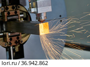 Laser cutting of metal pipe with sparks on tube laser machine. Стоковое фото, фотограф Дмитрий Калиновский / Фотобанк Лори