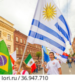 Russia, Samara, July 2019: a girl cheerleader holds the national flag of Uruguay in the procession of football fans on Kuibyshev street at the carnival dedicated to the World Cup. Редакционное фото, фотограф Акиньшин Владимир / Фотобанк Лори