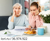 Mother and daughter figuring out finance problem. Стоковое фото, фотограф Яков Филимонов / Фотобанк Лори
