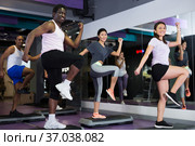 Group of people working out with steppers in fitness center. Стоковое фото, фотограф Яков Филимонов / Фотобанк Лори