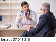 Old businessman visiting young male doctor in vaccination concep. Стоковое фото, фотограф Elnur / Фотобанк Лори