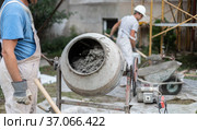 Labore worker operating concrete cement mixer at construction site. Стоковое фото, фотограф Matej Kastelic / Фотобанк Лори