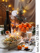 Traditional Russian Christmas Salad Olivier with champagne and tangerines. Стоковое фото, фотограф Марина Володько / Фотобанк Лори