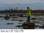 Отлив на Белом море. Валуны в воде. Мальчик на фоне Соловецкого монастыря. Стоковое фото, фотограф Яковлев Сергей / Фотобанк Лори