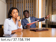 Saddened businesswoman sitting in office with dissatisfied male colleague. Стоковое фото, фотограф Яков Филимонов / Фотобанк Лори