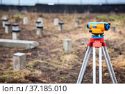 Construction surveying instrument, theodolite against cement piles field. Стоковое фото, фотограф Кекяляйнен Андрей / Фотобанк Лори