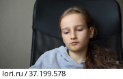 Little sad girl is sitting on black office chair, punishment, serious face. Стоковое видео, видеограф Ольга Балынская / Фотобанк Лори