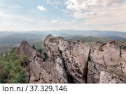 man and woman tourists on the rocky peak Aleksandrovskaya Sopka against the background of the city of Zlatoust on a summer sunny day. Стоковое фото, фотограф Акиньшин Владимир / Фотобанк Лори