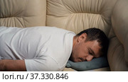 Tired exhausted millennial man falling down on sofa at home after hard working day, burnout concept. Стоковое видео, видеограф Данила Большаков / Фотобанк Лори