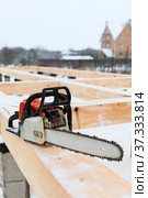 Chainsaw carpenter tool for building a frame house at winter season. Стоковое фото, фотограф Кекяляйнен Андрей / Фотобанк Лори