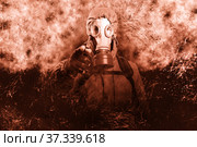 A shot of a man dressed in a gas mask, a jacket with a hood, a backpack, points his index finger into the camera. A poster on the background of grunge. Стоковое фото, фотограф Владимир Арсентьев / Фотобанк Лори