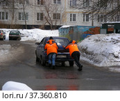 Молодые люди толкают заглохший на дороге автомобиль. Новосибирская улица. Район Гольяново. Город Москва (2013 год). Редакционное фото, фотограф lana1501 / Фотобанк Лори
