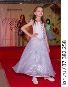Красивый нарядный ребенок выступает на детском конкурсе красоты. A beautiful dressed-up child performs at a children's beauty contest. (2021 год). Редакционное фото, фотограф Мария / Фотобанк Лори