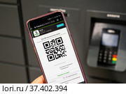 Moscow, Russia - Feb. 12. 2022. Receiving an order in Postamat Fivepost.ru by QR code in a mobile phone. Редакционное фото, фотограф Володина Ольга / Фотобанк Лори